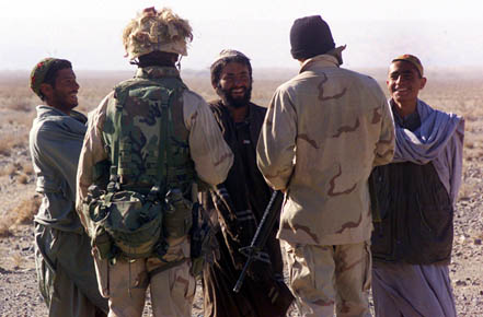 SOUTHERN AFGHANISTAN - Marines from the 15th Marine Expeditionary Unit (Special Operations Capable) talk with two Afghan locals at the perimeter of a patrol base here December 10, 2001. The Afghans expressed their thanks and offered food, water and any other support the Americans may have needed. The Marines politely declined.   Photo by: Sgt. Joseph R. Chenelly     